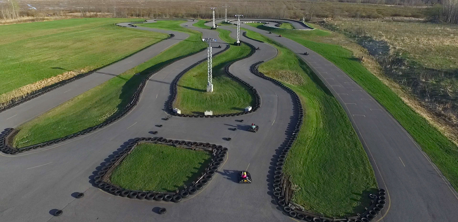 Notre piste vue des airs. On peut voir un poteau de lumière, la piste asphaltée ainsi que quelques karts et les pneus de sécurité qui entourent la piste.